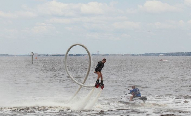 chica volando el mar mientras practica flyboard